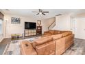 Cozy living room features modern ceiling fan, plush sectional sofa and a view of the staircase to the second floor at 4707 Hannah Dr, Rock Hill, SC 29732