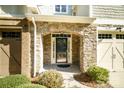 Inviting entryway with stone arch, glass door, and neatly landscaped surroundings at 8428 Loxton Cir, Charlotte, NC 28214