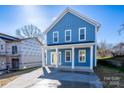 Charming blue two-story home with a welcoming front porch and newly paved driveway at 518 Herms Ave, Mount Holly, NC 28120