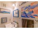 Small bathroom with a sink, mirror, and artistic wall decor at 3722 Park Rd # Q, Charlotte, NC 28209