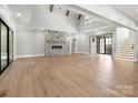 Spacious living room featuring a stone fireplace, high ceilings, and wood floors at 986 Pinnacle Dr, Iron Station, NC 28080