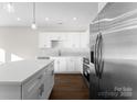White kitchen with stainless steel appliances and an island at 8603 Mcclure Cir, Charlotte, NC 28216