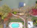 Stunning aerial view showcasing a pool, waterfront access with a dock, and lush landscaping at 271 Lockhard Cir, Troutman, NC 28166