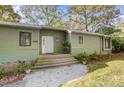 Charming single-story home with green siding, set amongst lush greenery at 11429 Spreading Oak Ln, Charlotte, NC 28226