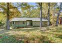 Exterior view of a one-story house surrounded by mature trees and a grassy yard at 11429 Spreading Oak Ln, Charlotte, NC 28226