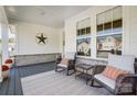Inviting front porch featuring comfortable seating, decorative pillows, and a welcoming star decoration on the wall at 4116 Spring Cove Way, Belmont, NC 28012