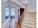 Elegant foyer with staircase, wood floors, decorative mirror, and a view into the dining room with chandelier at 6416 Red Maple Dr, Charlotte, NC 28277
