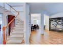 Inviting foyer showcasing a staircase, hardwood floors, and an open view into the dining and living areas at 6416 Red Maple Dr, Charlotte, NC 28277