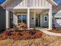 Inviting front porch area with stylish columns and a cozy bench at 1200 Meander Ln, Waxhaw, NC 28173