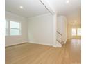 Open-concept living room with large windows providing natural light and hardwood flooring at 1200 Meander Ln, Waxhaw, NC 28173