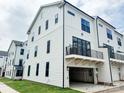 Exterior of new home featuring an attached garage and balcony area with modern design at 12126 Storm Ln # 53, Charlotte, NC 28277