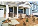 Inviting front porch with decorative columns, stone accents, and landscaping at 2608 Tillman St, Monroe, NC 28112