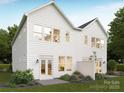 Rear exterior of a two-story home with white siding, a patio, and well-maintained landscaping at 9247 Eleanor Dr, Charlotte, NC 28214