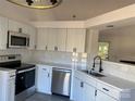 Modern kitchen featuring white cabinets, marble backsplash, and stainless steel appliances at 4500 Doves Nest Ct, Matthews, NC 28105