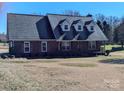 Brick ranch house with a gray roof, dormer windows, and a spacious yard at 2304 Fox Hunt Dr, Monroe, NC 28110