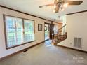 Bright living room with hardwood floors, a fireplace, and a staircase at 2304 Fox Hunt Dr, Monroe, NC 28110