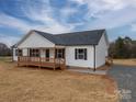 Exterior view of a home featuring a covered porch, gray roof, gravel driveway and white siding at 9303 Reepsville Rd, Vale, NC 28168