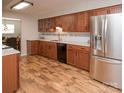 A spacious kitchen features stainless steel appliances, wood cabinets, granite counters, and hardwood floors at 10933 Hunter Trail Ln, Charlotte, NC 28226