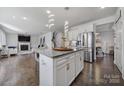 Well-lit kitchen with a granite island and stainless steel appliances leads to a cozy living room at 535 Red Wolf Ln, Clover, SC 29710