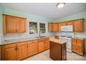 Functional kitchen featuring wood cabinetry, white appliances, and light countertops, perfect for cooking at 802 E Harrison Ave, Gastonia, NC 28054