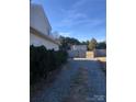 View of the backyard featuring a detached garage and a gravel drive at 8540 Indian Summer Trl, Harrisburg, NC 28075