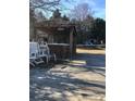 Covered outdoor bar with a wooden deck and several white Adirondack chairs at 8540 Indian Summer Trl, Harrisburg, NC 28075