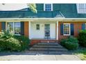 Inviting front porch with brick steps and black shutters, offering a classic and welcoming entry at 1018 Carysbrook Ln, Charlotte, NC 28217