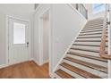 Bright entryway featuring hardwood floors, a staircase with wooden treads, and white trim at 15009 Brownleigh Ln # 26, Huntersville, NC 28078