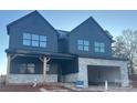 Two-story home showcasing a modern design with a two-car garage and a covered front porch at 15009 Brownleigh Ln # 26, Huntersville, NC 28078