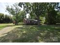Brick home with a spacious yard, mature trees, and a convenient storage shed in a tranquil setting at 2427 Rhyneland St, Gastonia, NC 28054