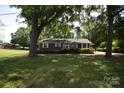 Attractive brick home with a lush green lawn and established trees, offering great curb appeal at 2427 Rhyneland St, Gastonia, NC 28054