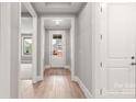 Inviting hallway with wood floors, leading to a bright entrance with a glass-paneled door at 4440 Moxie Way, Charlotte, NC 28215