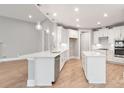 Modern kitchen boasts white cabinets, quartz countertops, stainless steel appliances, and pendant lighting at 4440 Moxie Way, Charlotte, NC 28215