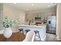 Modern kitchen features stainless steel appliances, quartz countertops, and barstool seating at 8021 Joy Crossing Ln, Charlotte, NC 28214