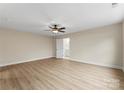 Large bedroom featuring neutral walls, ceiling fan and light fixture, and door to ensuite bathroom at 1916 Irma St, Charlotte, NC 28216