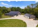 Aerial view showing a large metal building with attached garage and additional detached garage at 5070 Woodleaf Rd, Salisbury, NC 28147