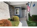 Inviting covered porch with brick accents and a glimpse of the home's exterior at 6296 Raven Rock Dr # 725, Denver, NC 28037