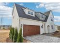 Stunning home showcases a spacious two-car garage, inviting arched entryway, and lush green landscaping at 817 Terra Dr, Tega Cay, SC 29708