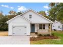 Charming white farmhouse style home with a blue door and landscaped yard at 2443 Myrtle Ave, Gastonia, NC 28052