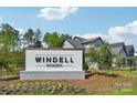 Windell Woods community entrance sign with landscaped surroundings under a blue sky with some clouds at 809 Terra Dr, Tega Cay, SC 29708