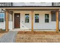 Inviting covered front porch featuring exposed wooden beams, brick accents, and a stylish front door at 809 Terra Dr, Tega Cay, SC 29708