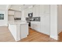 Modern kitchen boasts white cabinets, a gray backsplash, stainless steel appliances and center island at 821 Terra Dr, Tega Cay, SC 29708