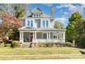 Charming two-story home featuring a welcoming front porch, beautiful landscaping, and classic architectural details at 70 Spring Nw St, Concord, NC 28025