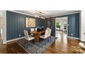 Elegant dining room with dark-blue walls, oval table, and hardwood floors at 1915 Wedgedale Dr, Charlotte, NC 28210