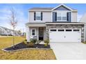 Charming two-story home featuring stone veneer, a two-car garage, and a well-maintained lawn at 159 Tanner Loop, Troutman, NC 28166