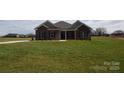 Traditional brick house with a green lawn, featuring symmetrically placed windows and simple landscaping for a neat appearance at 3034 Buffet Ln, Monroe, NC 28110