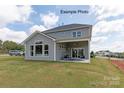 Gray house with a covered patio and seating area, overlooking a manicured lawn at 1017 Wandsworth Pl # Ken0108, Charlotte, NC 28215