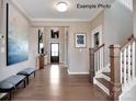 Spacious foyer with hardwood floors, a staircase, and large artwork at 1017 Wandsworth Pl # Ken0108, Charlotte, NC 28215