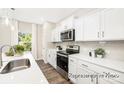 Well-lit kitchen showcasing white cabinets, stainless steel appliances, and gray subway tile backsplash at 1027 Freeman View Dr # 151P, Albemarle, NC 28001