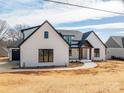 This shot shows a lovely white brick home with black trim, a driveway leading to a two-car garage, and manicured landscaping at 229 Golf Course Rd, Maiden, NC 28650